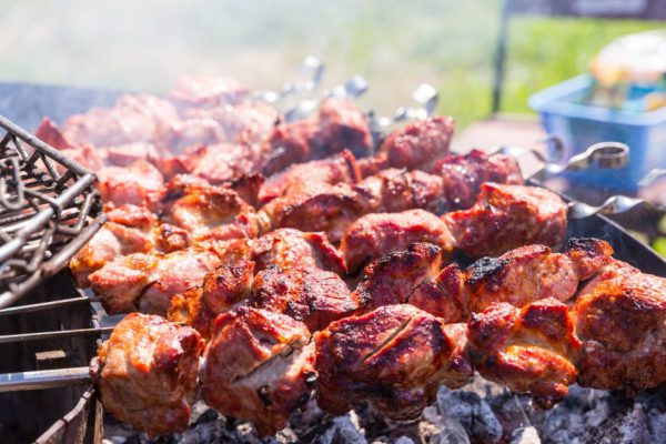 Tasty kebab on skewers prepares on fire outdoor