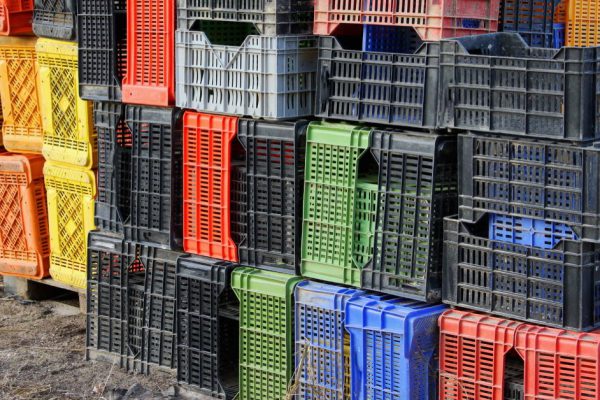 lots of colored plastic box for collecting fruits and grapes on the farm