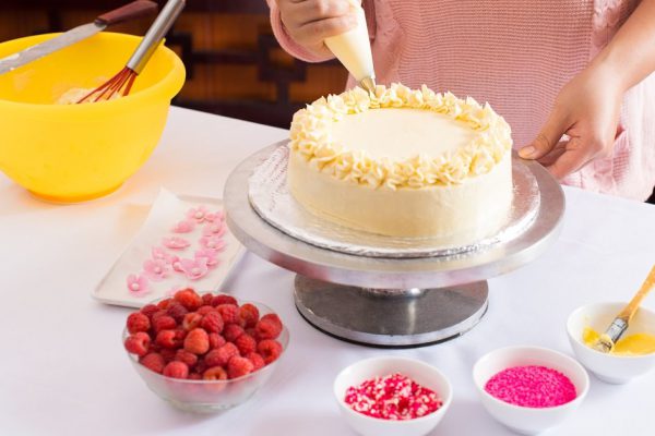 Close-up of woman decorating cake