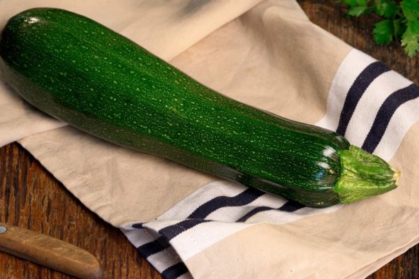 Fresh zucchini on wooden rustic table with parsley close up