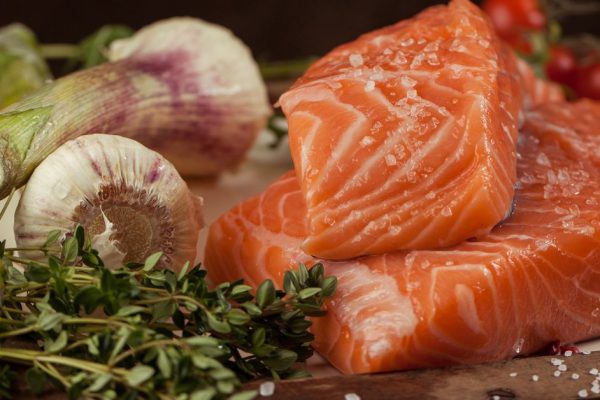 salted fresh salmon fish on vintage board with vegetables and spice