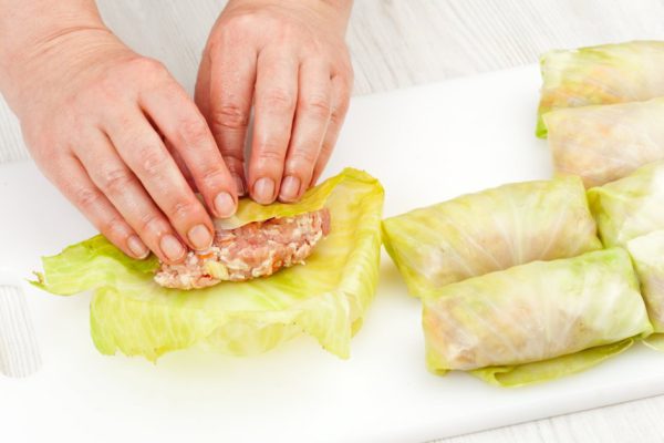 chef prepares stuffed cabbage rolls on a cutting board closeup