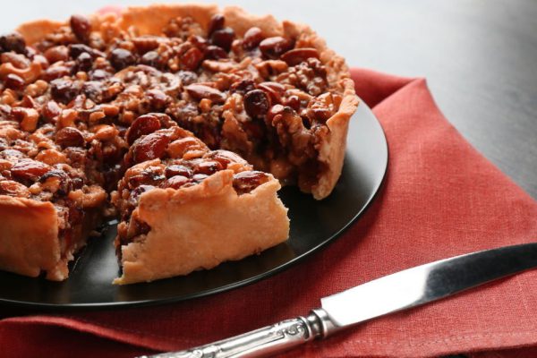 Delicious cake with nuts on table