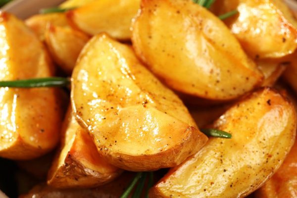 Baked potato wedges in bowl, closeup