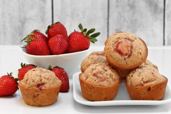 Freshly baked organic strawberry muffins, with whole fresh berries.