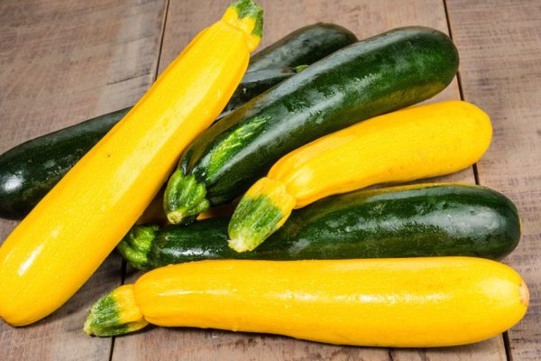 Zucchini and yellow squash displayed on a wooden table