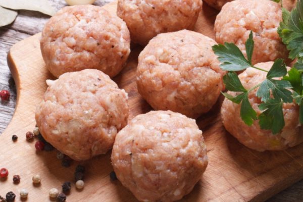raw meatballs on a chopping board and ingredients. view from above. macro