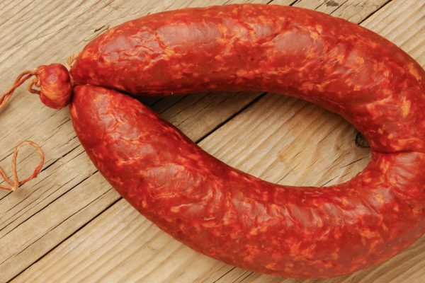 Krakow sausage isolated on the wooden table