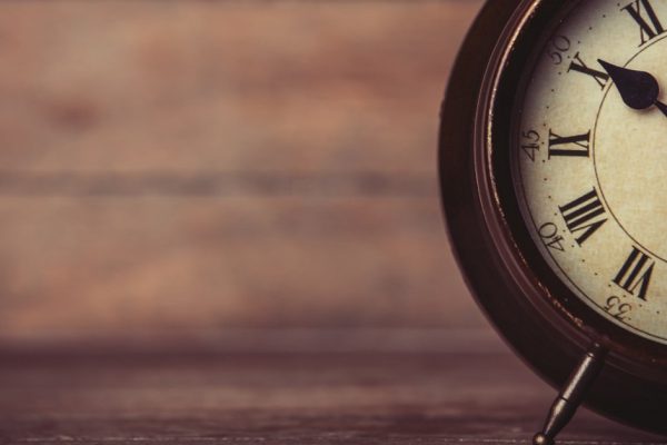 Retro alarm clock on a table. Photo in retro color image style