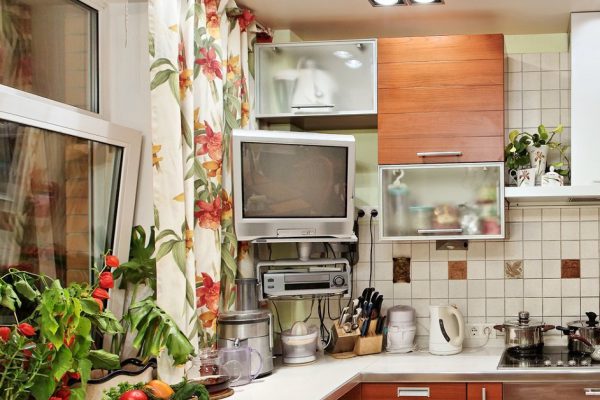 Kitchen interior with wooden furniture and many utensils in warm tones on wide angle view