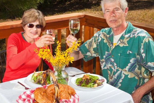Happy middle aged couple dining at an outdoor cafe.