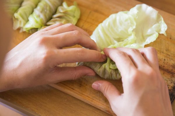 A portrait of processing to make a meat wrap in cabbage