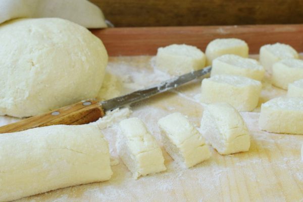 Making traditional russian or ukrainian cottage cheese lazy dumplings on wooden background. Italian gnocchi.