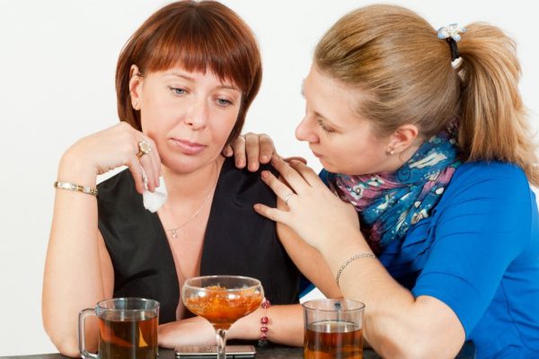 A friend comforts in a conversation over tea