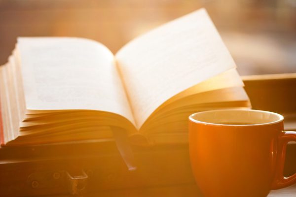 Books and a coffee cup on a windowsill