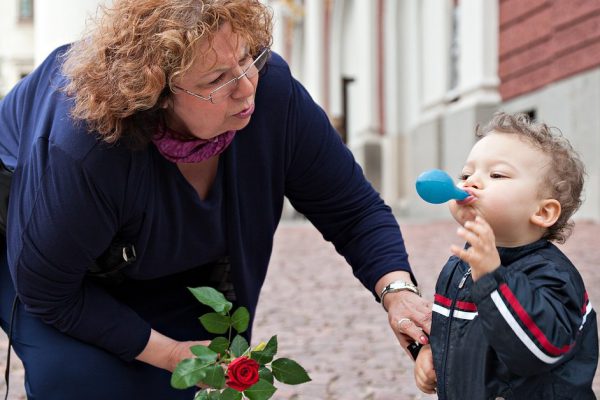 grandmother is thaking care of a smoll boy outdoors