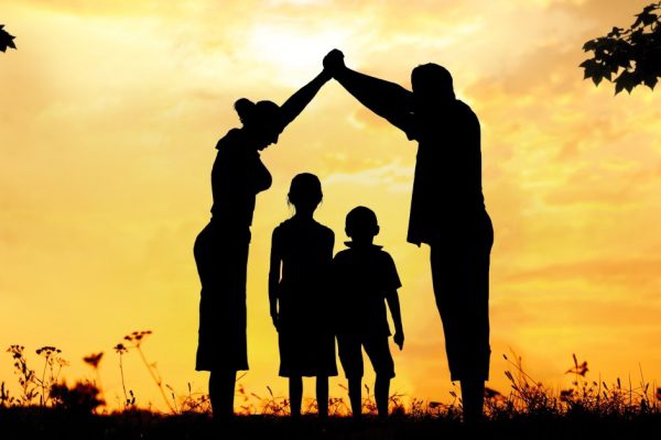 Silhouette, group of happy children playing on meadow, sunset, summertime