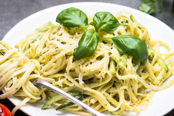 Pasta spaghetti with zucchini basil and cheese.