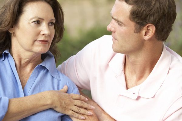 Senior Woman Being Comforted By Adult Son