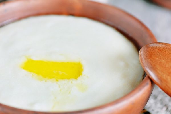 Semolina porridge with melted butter in the clay plate