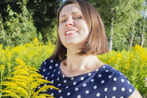 young happy girl surrounded by bright yellow flowers.