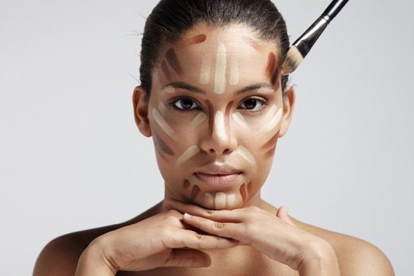 facial contouring. Woman with a different shades of foundation on her face