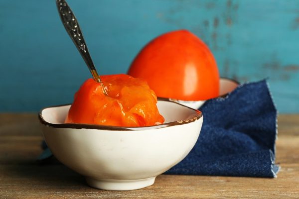 Ripe sweet persimmons, on wooden table