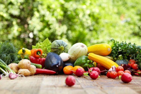 Fresh organic vegetables ane fruits on wood table  in the garden