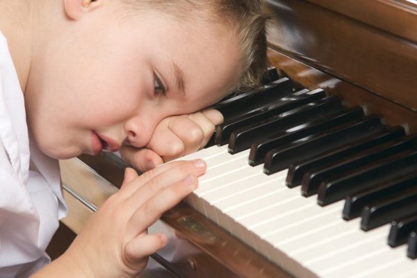 Young Boy with Head on Hand Playing the Piano