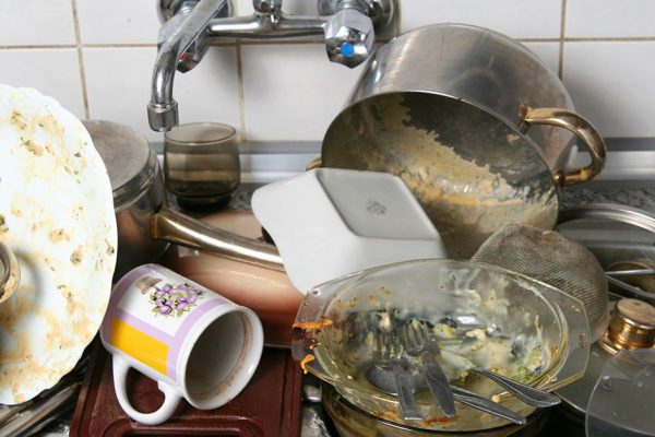 Pile of dirty dishes in the metal sink