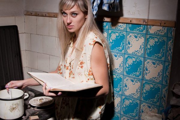 A girl is in an old kitchen