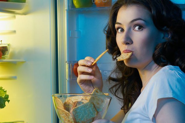 a hungry girl opens the fridge