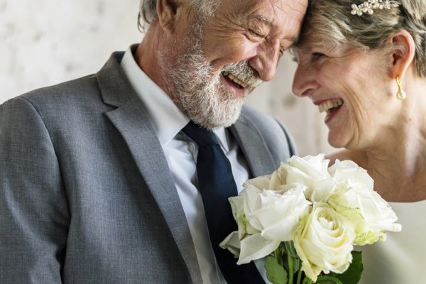 Senior Couple with White Roses Flower Bouqet