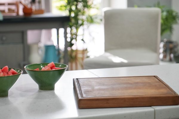 Cutting board and bowls with sliced watermelon on kitchen table