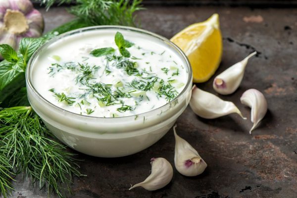 Tzatziki sauce with ingredients cucumber, garlic, dill, lemon, mint. Healthy food background