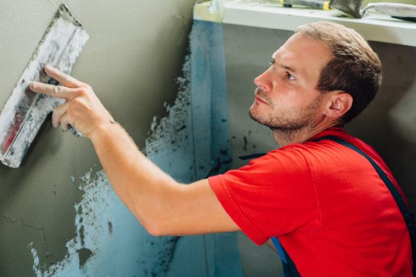close up plasterer concrete worker at wall