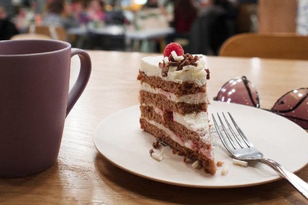 Still life in a cafe. A Cup of coffee or tea, the plate of half-eaten cake. To give up sweets.