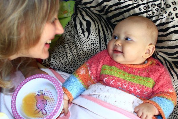 nursing of little baby from childish spoon