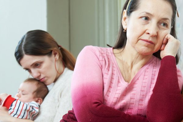 Mature mother and adult daughter with baby after quarrel at home