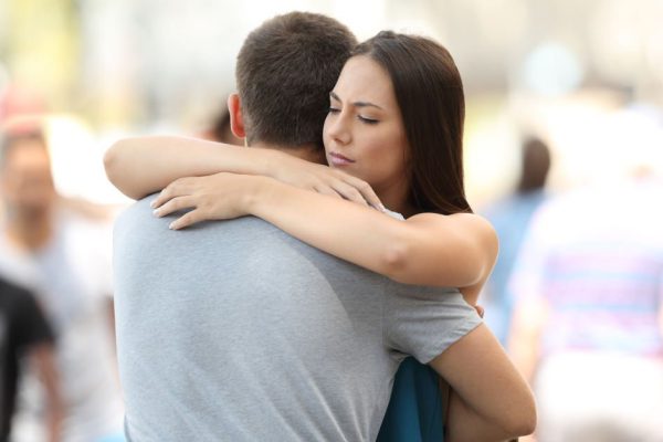 Couple with problems hugging on the street
