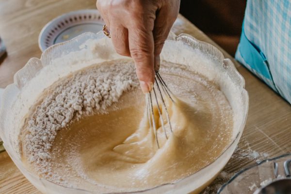 adult woman in the kitchen kneading the mix for sweets and desserts