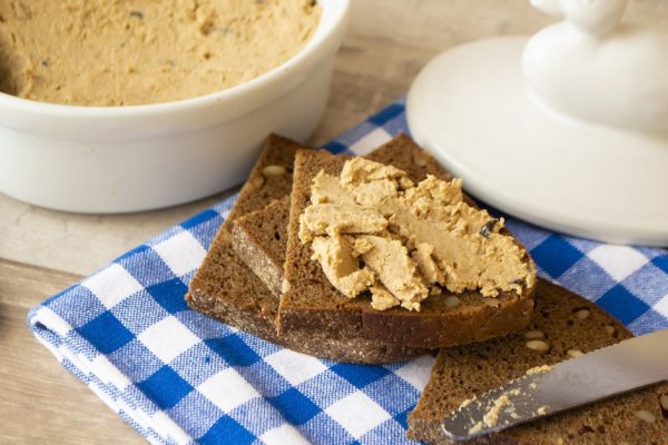 the pate of duck with bread on wooden table.