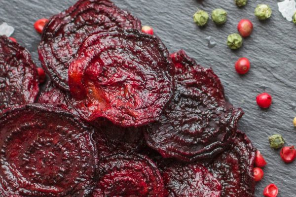 Carrots and beets . Healthy organic vegetable chips with coarse sea salt, pepper and coriander. Selective focus