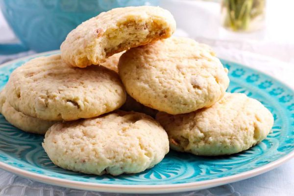 Coconut crunchy cookies on blue plate and cappuccino