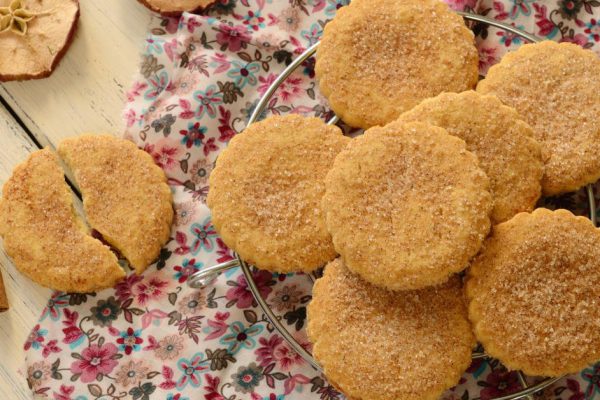 Apple cookies powdered with sugar and cinnamon on wooden table
