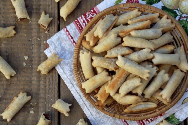 small, traditional Italian cookies, bagels, kaltsonchelli,  kifliki with almonds and chocolate of phyllo dough in the basket