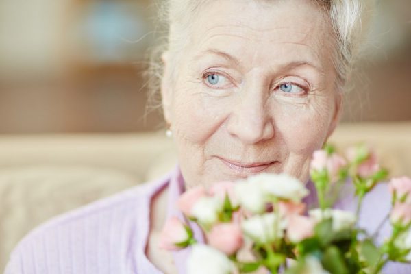Portrait of senior woman with flowers