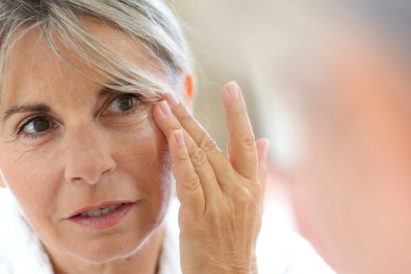 Senior woman applying anti-wrinkles cream