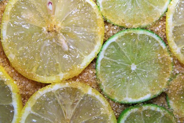 view on slices of limes and lemons mixed with cane sugar placed flat on the ground