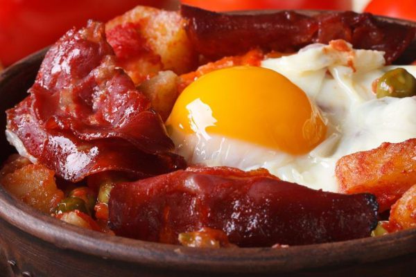 baked eggs with chorizo and vegetables in a pot on the Spanish recipe. close up horizontal